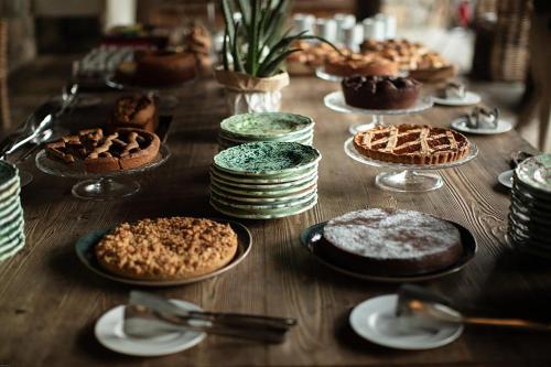 a wooden table with pies and cakes on plates at Aquapetra Resort & Spa in Telese