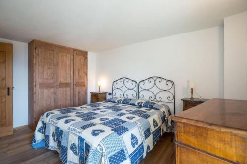 a bedroom with a bed with a blue and white blanket at Morge La Salle in La Salle
