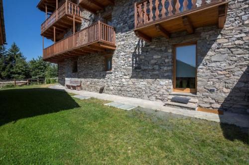 a stone house with two decks and a yard at Morge La Salle in La Salle