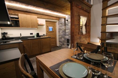 eine Küche und ein Esszimmer mit einem Tisch und Weingläsern in der Unterkunft Lo Mieton - Affitti Brevi Italia in Champoluc