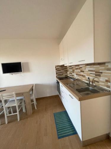 a small kitchen with a sink and a table at case al borgo in Porto Pollo