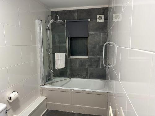 a white bathroom with a tub and a shower at The Angel Hotel in Alton