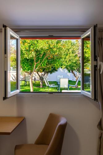 a window in a room with a chair and trees at Tinas Village Free Transport from/to the airport in Spáta