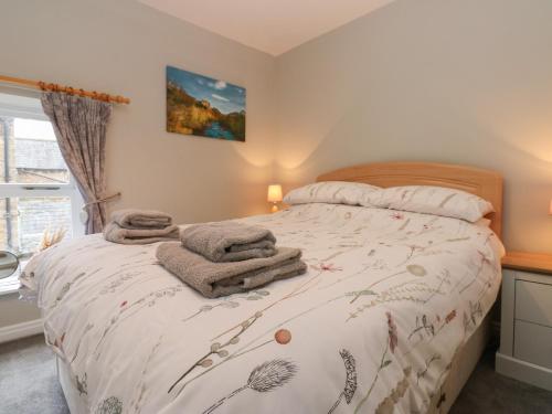 een slaapkamer met een bed met handdoeken erop bij Foxglove Cottage in Richmond