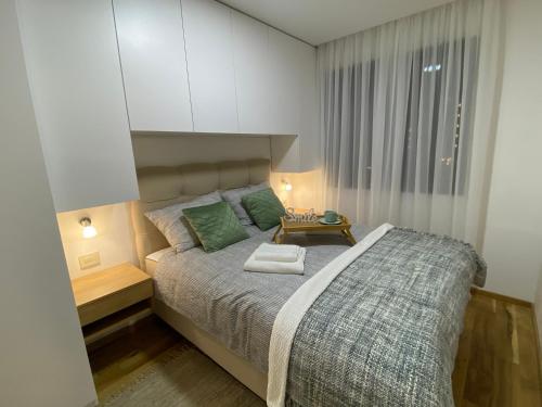 a bedroom with a bed and a white cabinet at Apartman ConVista Zlatibor in Zlatibor