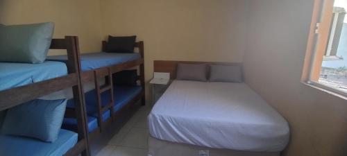 a small room with two bunk beds and a window at Casa com Piscina em Ubatuba in Ubatuba