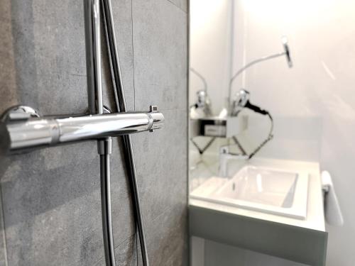 eine Duschtür mit Waschbecken im Bad in der Unterkunft Grimm's Potsdamer Platz in Berlin