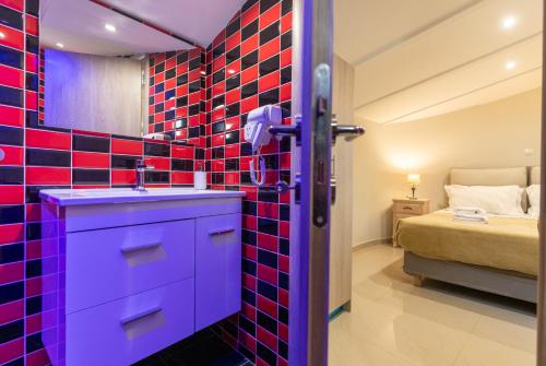 a bathroom with a blue sink and red tiles at Tinas Village Free Transport from/to the airport in Spáta