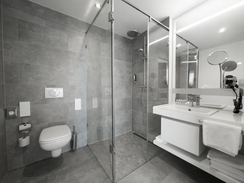 a bathroom with a toilet and a sink and a shower at Grimm's Potsdamer Platz in Berlin