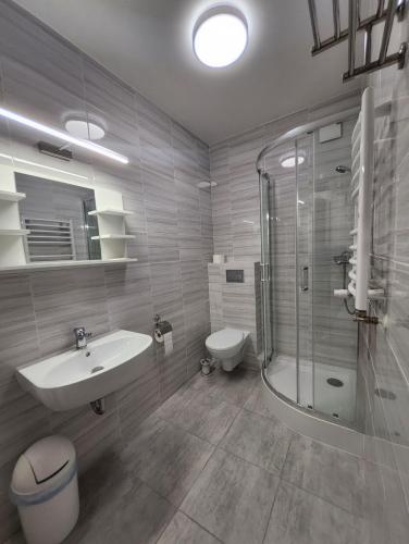uma casa de banho com um lavatório, um chuveiro e um WC. em Hotel Resident em Suchedniów