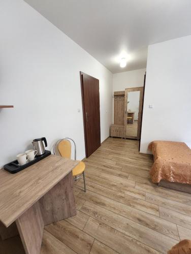 um quarto com uma mesa de madeira e uma cama em Hotel Resident em Suchedniów