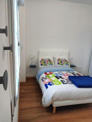 a bedroom with a bed with colorful pillows on it at Sleep & Fly Villa Luisa in Case Nuove