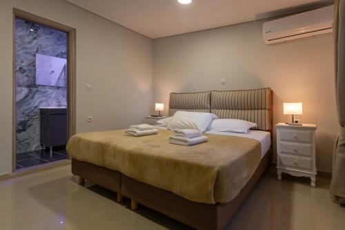a bedroom with a large bed with towels on it at Tinas Village Free Transport from/to the airport in Spáta