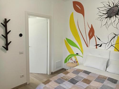 a bedroom with a bed with a flower mural on the wall at Sleep & Fly Villa Luisa in Case Nuove