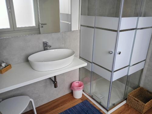 bagno con lavandino e doccia in vetro di Sleep & Fly Villa Luisa a Case Nuove