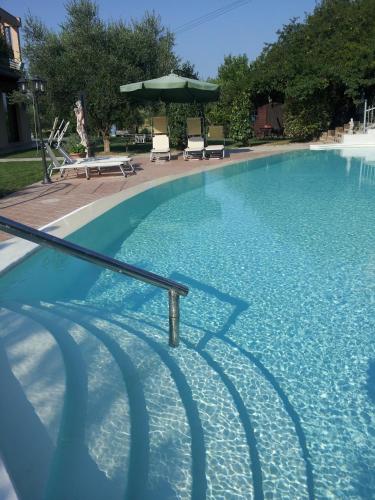 a large swimming pool with chairs and an umbrella at Luconi Affittacamere in Iesi