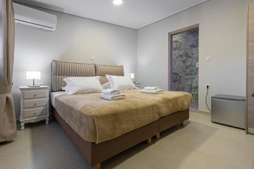 a bedroom with a large bed with towels on it at Tinas Village Free Transport from/to the airport in Spáta