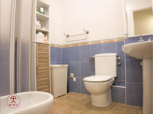a bathroom with a toilet and a sink and a tub at Las Palmeras in San José