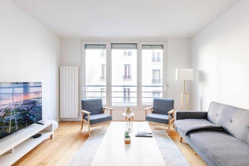 3 bedroom flat close Montmartre في باريس: غرفة معيشة مع أريكة وتلفزيون