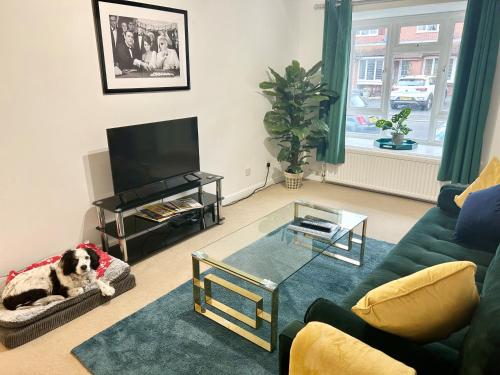 a living room with a dog laying on a couch at KB51 Charming 2 bed house in Horsham, pets very welcome and long stays with easy access to London, Brighton and Gatwick in Warnham