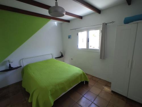 Un dormitorio con una cama verde y una ventana en Vista del Sur en Alajeró