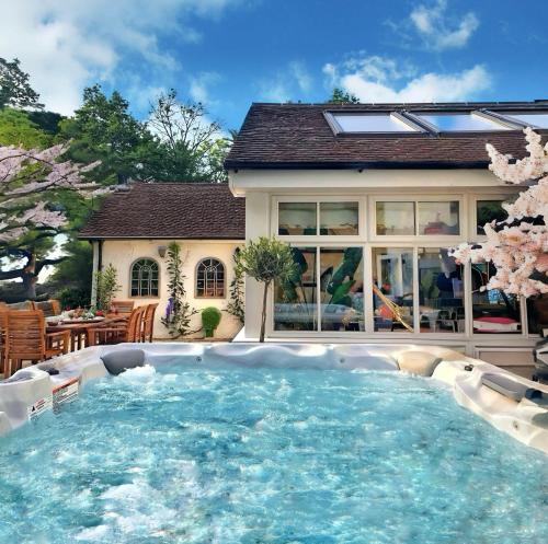a large swimming pool in front of a house at Daweswood Guest Suite - Luxury retreat with optional hot tub in Canterbury