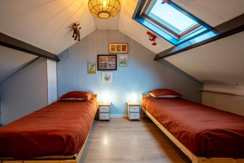 Schlafzimmer im Dachgeschoss mit 2 Betten und einem Fenster in der Unterkunft EftelHuysje in Sprang-Capelle