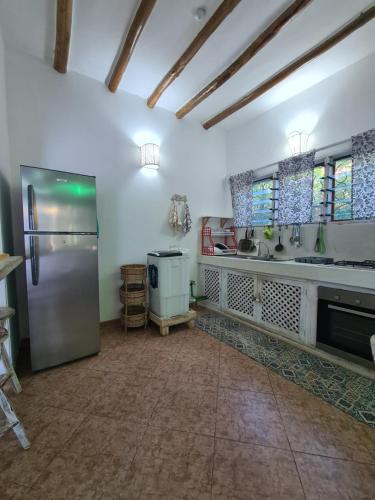 a kitchen with a stainless steel refrigerator and windows at Villa Yasmin in Watamu