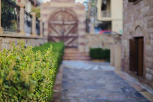 an alley with an archway in a building with plants at Archontiko Frideriki Luxury Apartments in Chios
