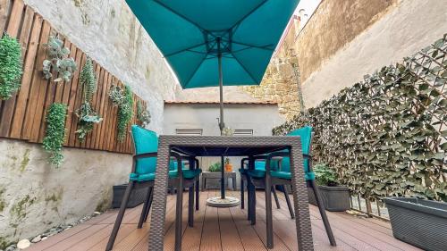 una mesa con sillas y una sombrilla en el patio en Almada Apartments 468, en Oporto