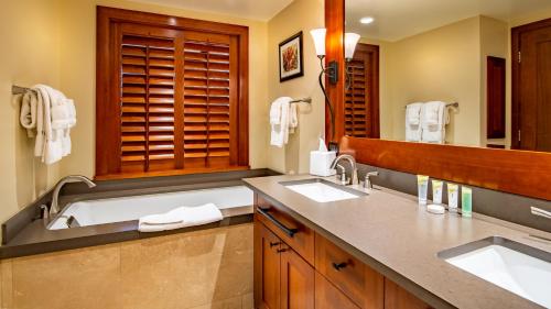 a bathroom with two sinks and a bath tub at Ko Olina Beach Villas B505 in Kapolei