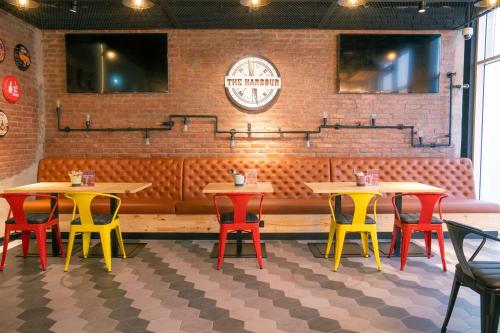 a restaurant with tables and chairs in front of a brick wall at Hilton Garden inn Dubai Jumeirah in Dubai
