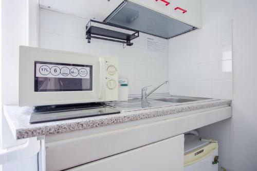 uma cozinha com um micro-ondas e um lavatório em Vatican Apartments 1-2 em Roma