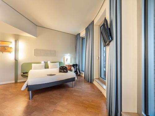 a hotel room with a bed and a television at ibis budget Frankfurt City Ost in Frankfurt