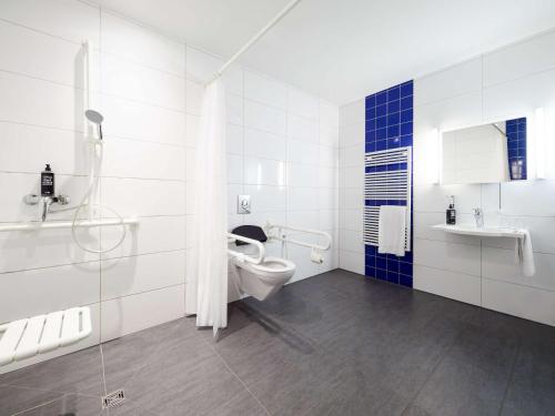 a white bathroom with a toilet and a sink at ibis budget Frankfurt City Ost in Frankfurt/Main