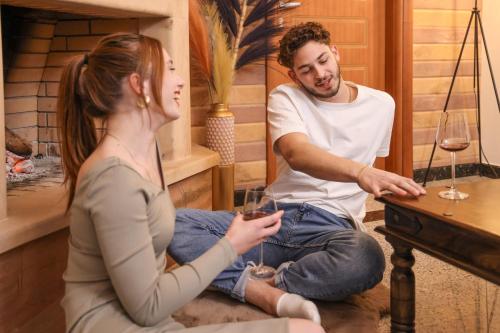 a man and a woman sitting on the floor with wine glasses at Archontiko Frideriki Luxury Apartments in Chios