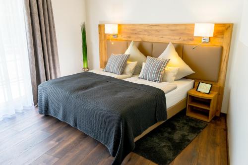 a bedroom with a large bed with two pillows at Landhotel Lebensart in Xanten