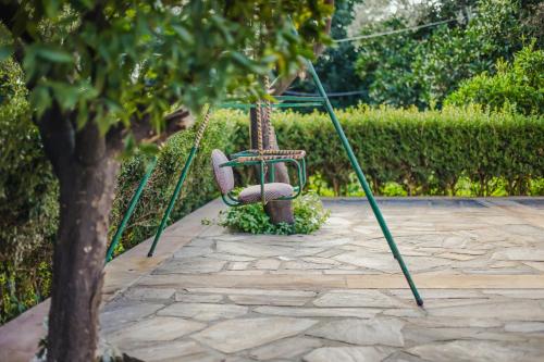 a swing in a garden next to a tree at Archontiko Frideriki Luxury Apartments in Chios