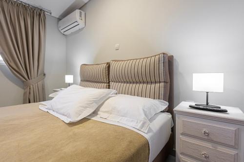 a bedroom with a bed and a night stand with a lamp at Tinas Village Free Transport from/to the airport in Spáta