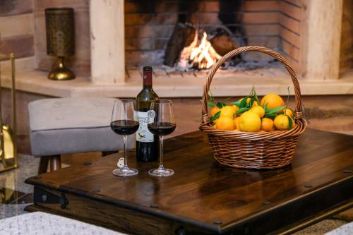a table with two glasses of wine and a basket of fruit at Archontiko Frideriki Luxury Apartments in Chios