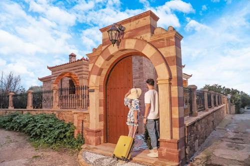 a man and a woman standing in a gate with a suitcase at Archontiko Frideriki Luxury Apartments in Chios