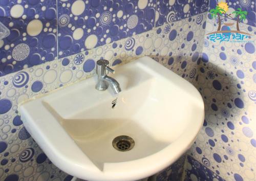 La salle de bains est pourvue d'un lavabo blanc et d'un mur. dans l'établissement Saghar House, à Visakhapatnam