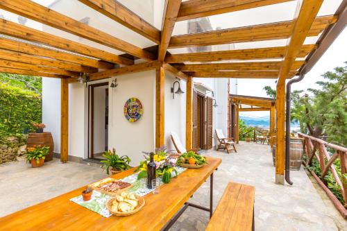 a wooden table on the patio of a house at Starhost - La Casella seaview garden terrace and parking in Cetara