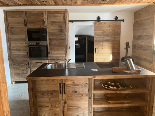 - une cuisine avec des placards en bois, un évier et un comptoir dans l'établissement Chalet Paula, à Ehrwald