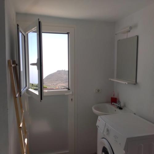 a bathroom with a window and a washing machine at Vistas del Sur in Alajeró