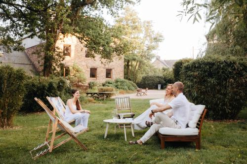 a group of people sitting on chairs in a yard at Chambre d'hôte en Gîte - Moulin de la Houssaie - Brocéliande in Guer