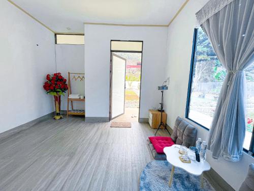 ein Wohnzimmer mit einem Sofa und einem großen Fenster in der Unterkunft MỘC CHÂU HOUSE in Mộc Châu