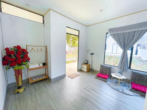 ein Wohnzimmer mit einer Vase aus Blumen und einem Fenster in der Unterkunft MỘC CHÂU HOUSE in Mộc Châu