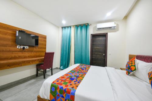 a bedroom with a bed and a desk and a tv at Hotel HC Dream Majestic in Mohali