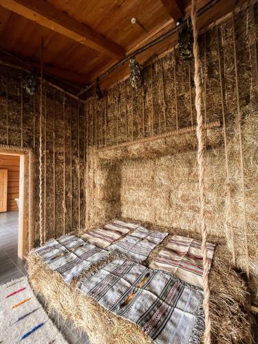 a large bed in a room with hay at Charlton Estate in Yablunytsya